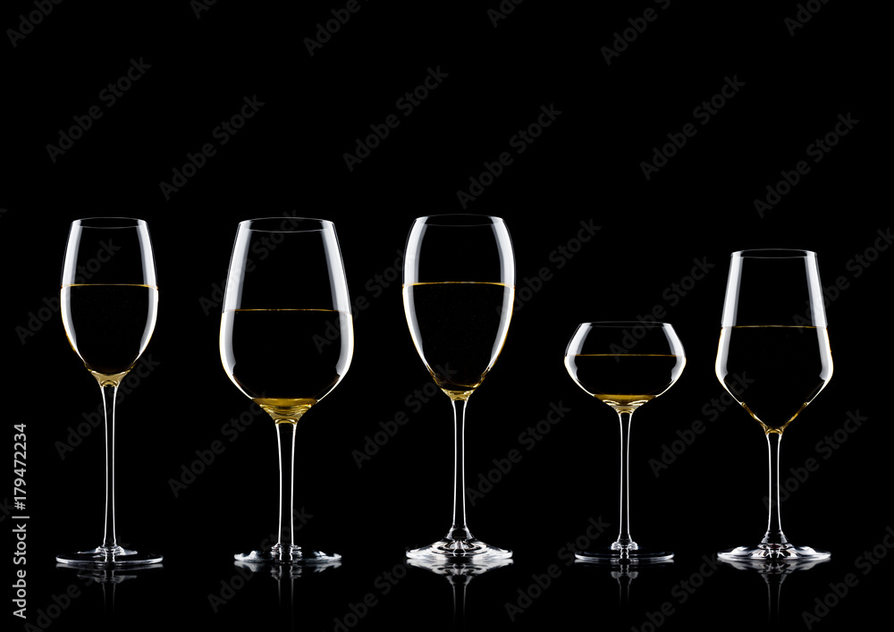 Glasses of white wine on black with reflection