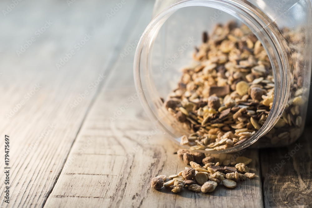 Close-up of muesli spilling from bowl on the wooden table
