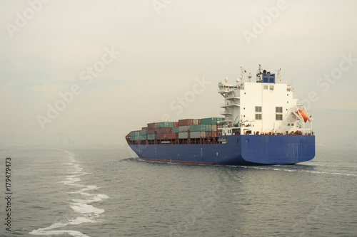 Blue container ship cruising at sea.