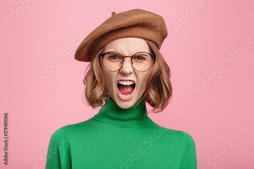 Photography Furious irritated woman screams in despair, frowns face, being disturbed by something, quarrels with someone, confident in her rightness