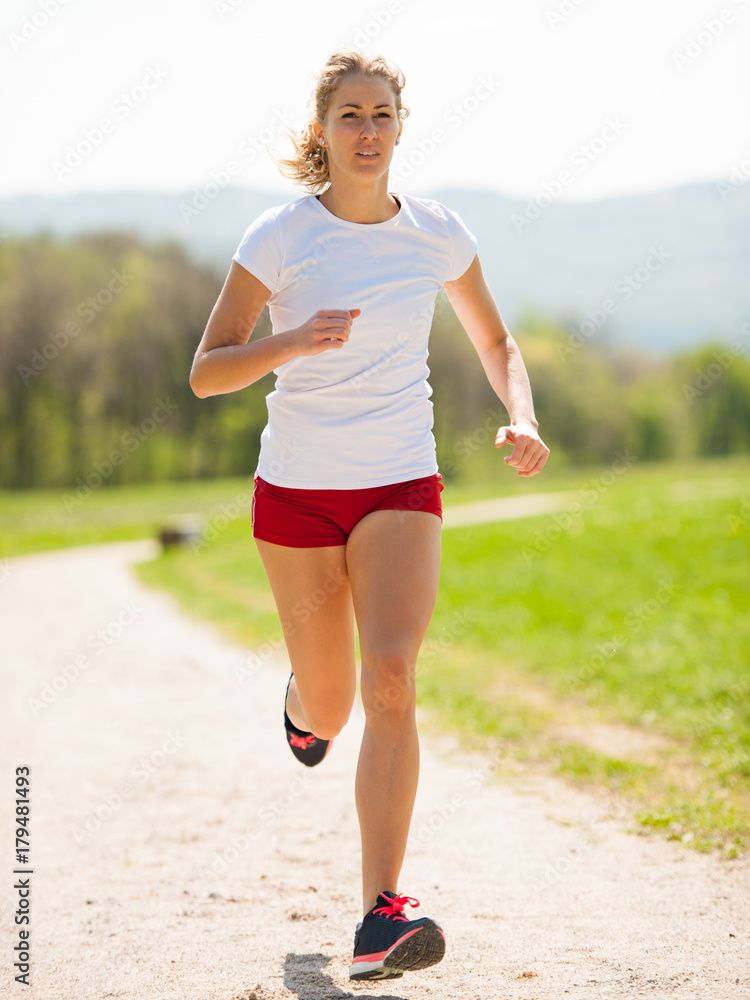 Woman runner runs - workout in spring Woman runner runs - workout in spring