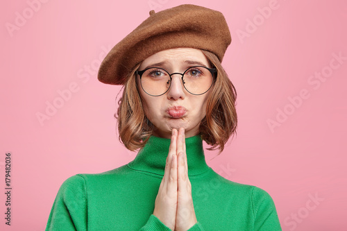 Photos Beautiful woman wears old fashionable clothes, keeps palms pressed together in f