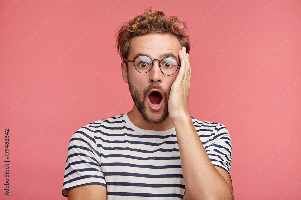 Stupefied emotional shocked attractive fashionable man keeps hand on head, forgets to pay for utilities, has no access to internet, being in panic as needs it immediately, Astonishment concept Stupefied emotional shocked attractive fashionable man keeps hand on head, forgets to pay for utilities, has no access to internet, being in panic as needs it immediately, Astonishment concept