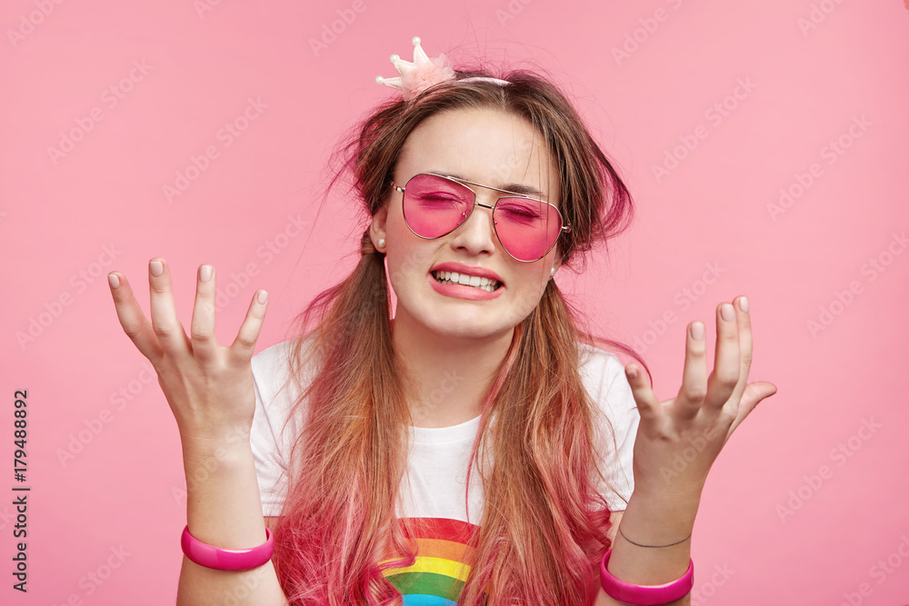 Stressful heart brocken woman with pony tails, wears bracelets, cries in despair, has good mood, being in hysterics, upset to hear dramatic information, isolated over pink background. Negative emotion Stressful heart brocken woman with pony tails, wears bracelets, cries in despair, has good mood, being in hysterics, upset to hear dramatic information, isolated over pink background. Negative emotion