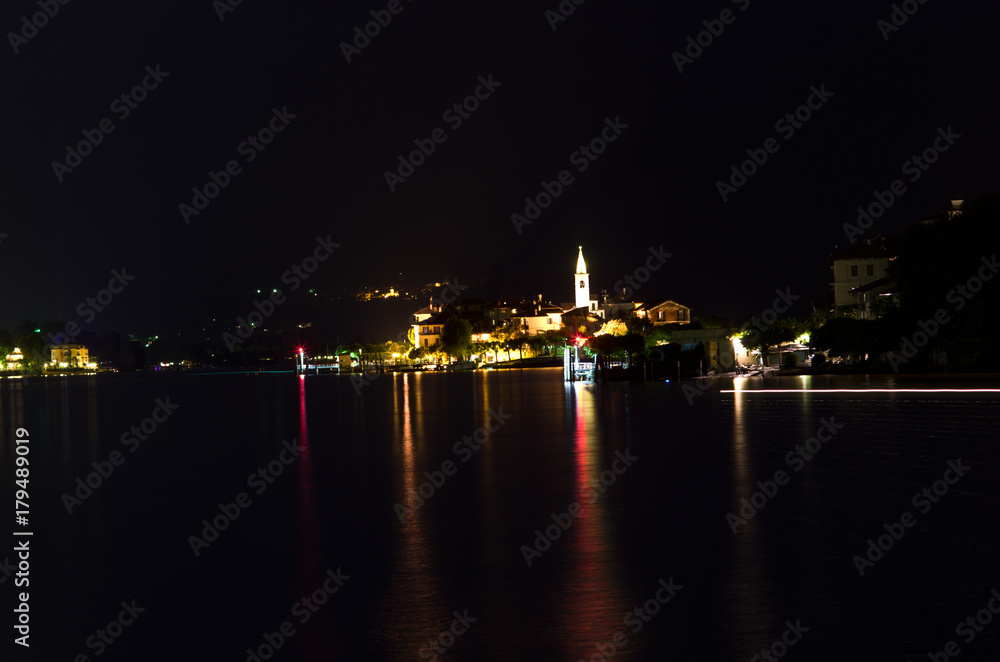 night on Pescatori Island, one of the Borromean Islands of the Maggiore Lake, which rises the dark water with the reflections of its lights