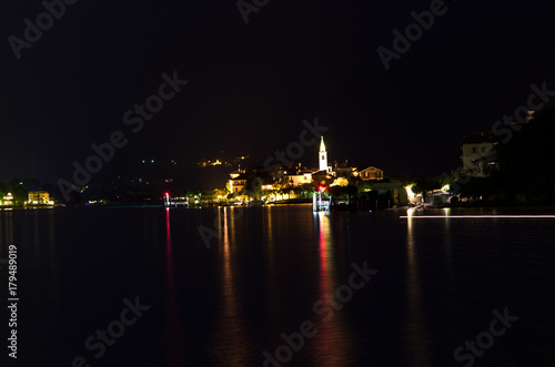 night on Pescatori Island, one of the Borromean Islands of the Maggiore Lake, which rises the dark water with the reflections of its lights
