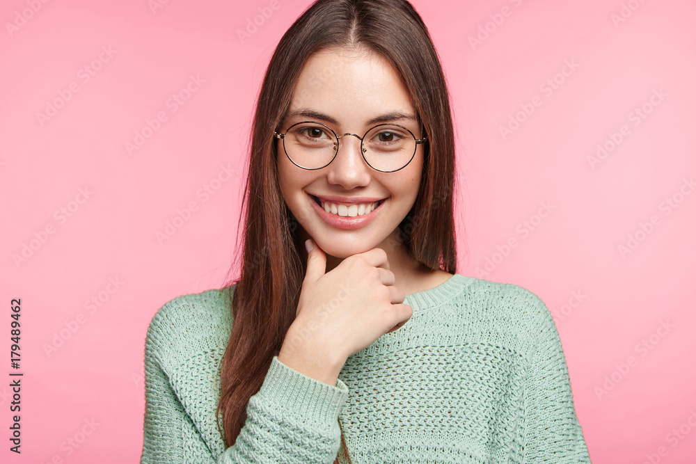 Studio shot of confident happy woman with dark hair, has charming smile, has good mood after celebrating special event or occasion with friends, had well organised party. Positive emotions concept Studio shot of confident happy woman with dark hair, has charming smile, has good mood after celebrating special event or occasion with friends, had well organised party. Positive emotions concept