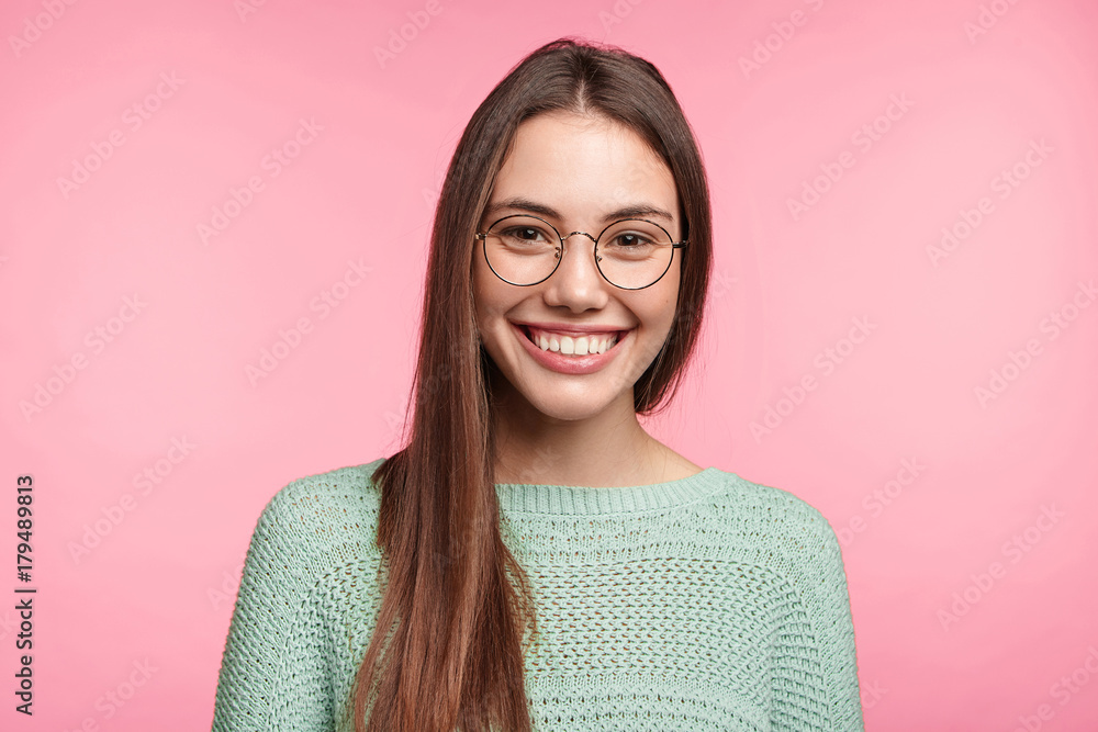 Fototapeta premium Happy Asian woman with long hair, has broad smile, shows white even perfect teeth, glad to meet handsome man, have pleasant conversation together, share opinions and compliments to each other