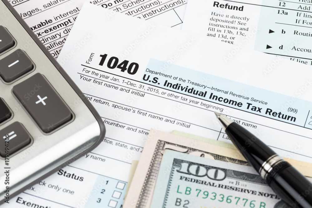 Tax form with calculator, pen, and dollar banknote Tax form with calculator, pen, and dollar banknote