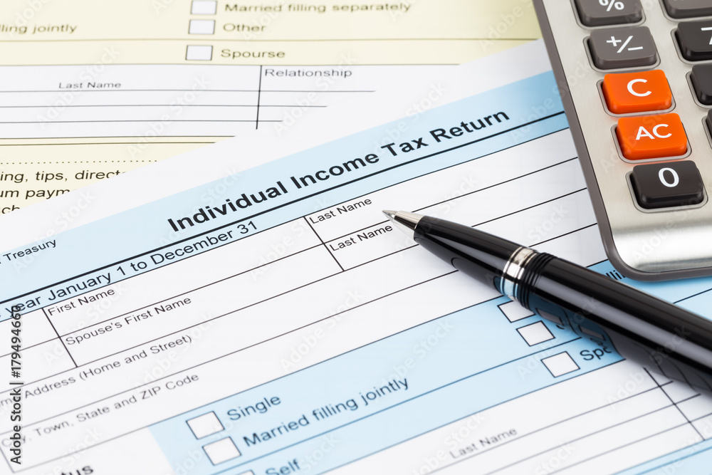 Tax form with pen and calculator; document are mock-up Tax form with pen and calculator; document are mock-up