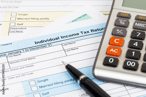 Tax form with pen and calculator; document are mock-up