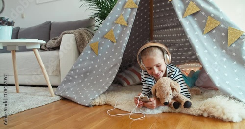 Girl using phone listening music in bivvy at home photo