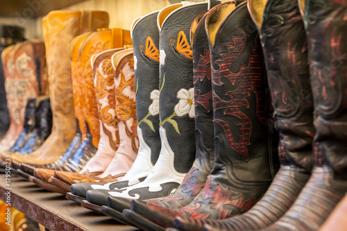 Cowboy boots on a shelf in a store aligned