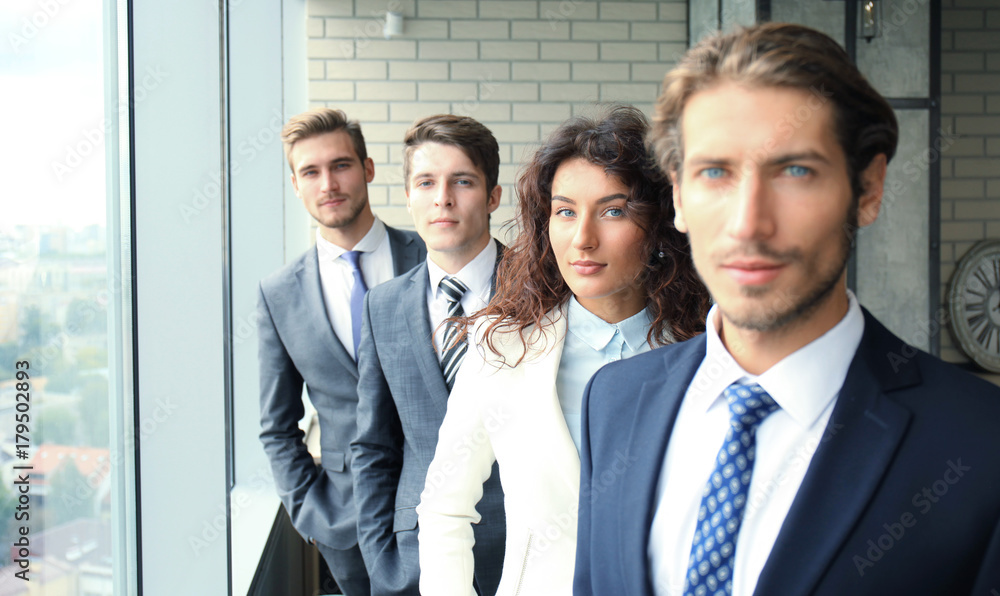 Happy smiling business team standing in a row at office. Happy smiling business team standing in a row at office.