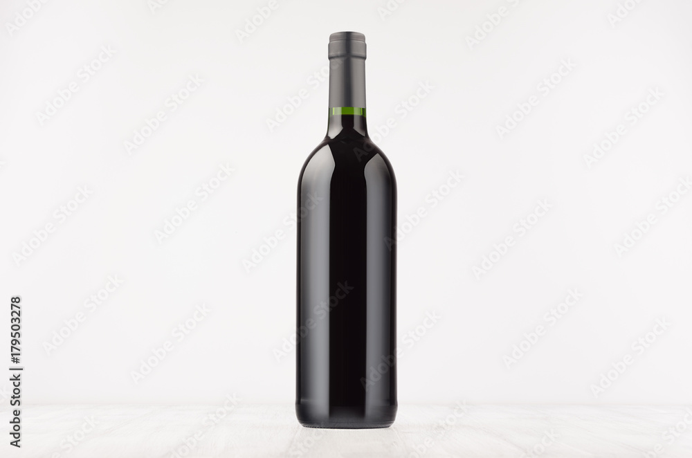 Black wine bottle with red wine on white wooden board, mock up. Template for advertising, design, branding identity. Black wine bottle with red wine on white wooden board, mock up. Template for advertising, design, branding identity.