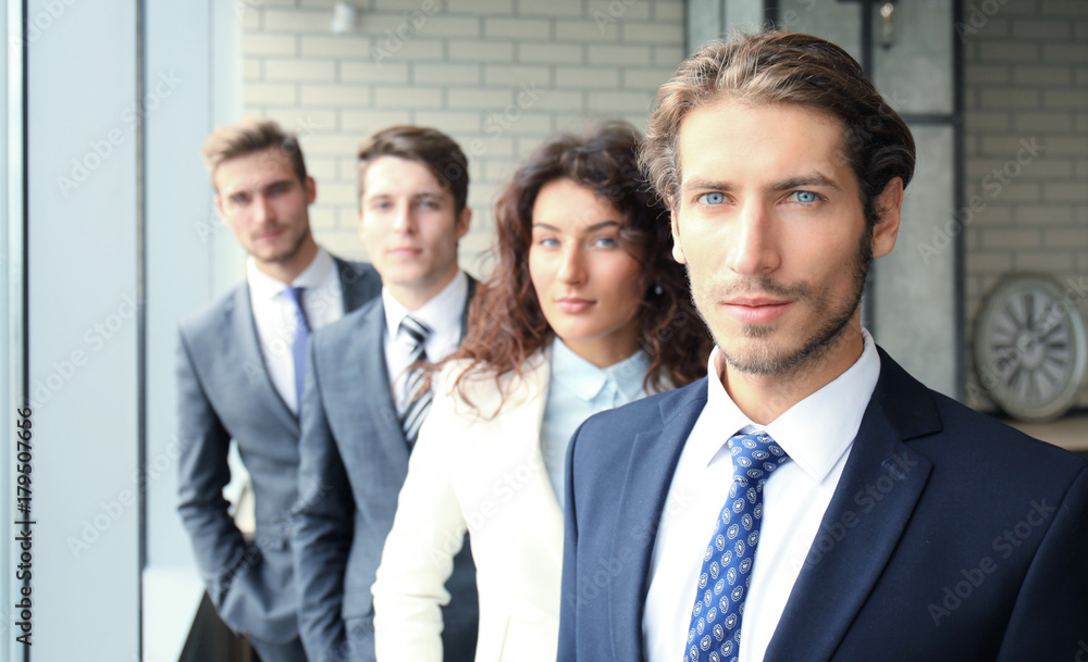Happy smiling business team standing in a row at office. Happy smiling business team standing in a row at office.