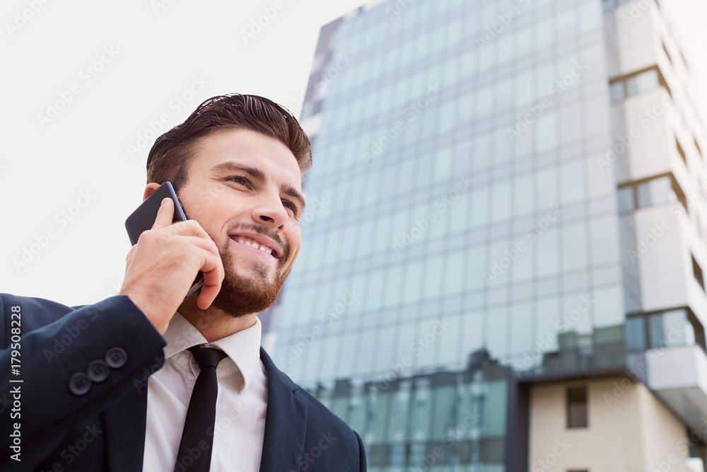 Businessman speaks on the phone outdoors. Business people. Businessman speaks on the phone outdoors. Business people.