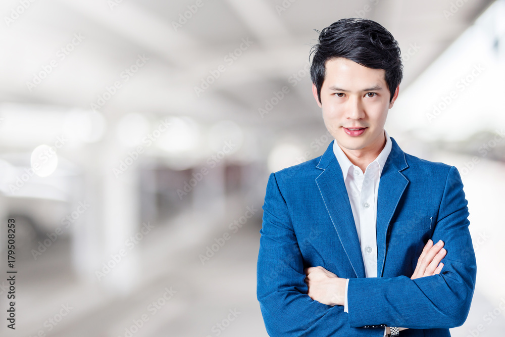 smart asian businessman in blue suit with BLUR IMAGE OF PARKING LOT BACKGROUND USAGE smart asian businessman in blue suit with BLUR IMAGE OF PARKING LOT BACKGROUND USAGE