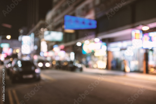 abstract blur and defocused Hong Kong street at night background, old film look effect © happycreator