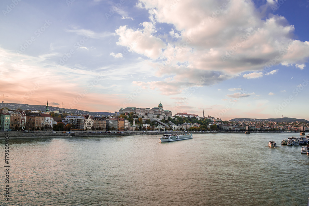 Panoramic city view at dusk from river Danube, Budapest, Hungary. Cityscape across the river to the Chain Bridge and historic buildings on Buda hills.