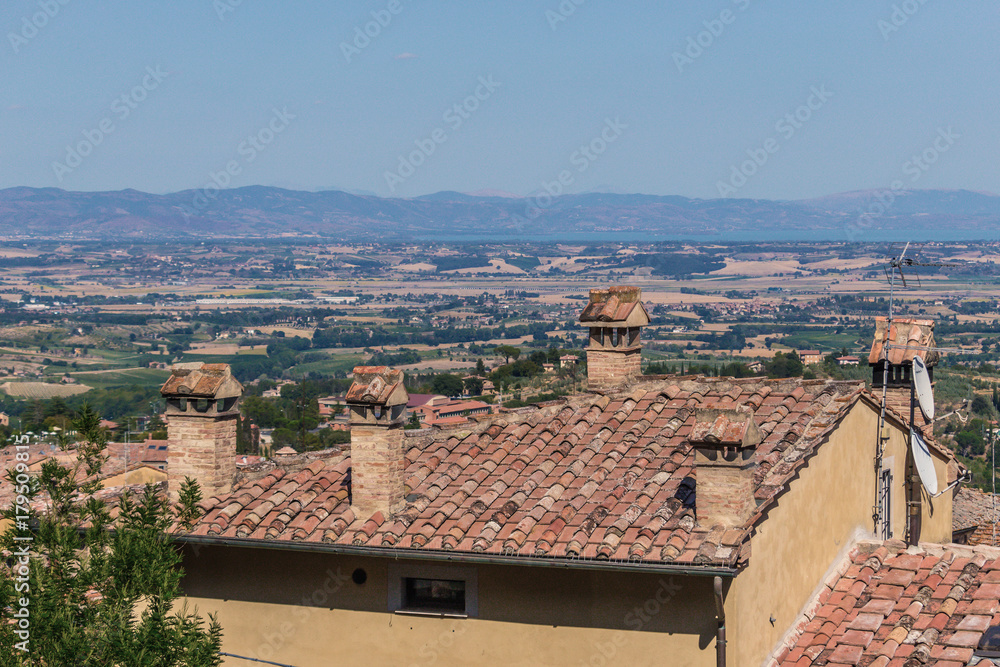 Grand vista overlooking Tuscan valley outside of Montepulciano, featuring a traditional Italian home with terra-cotta tiles.  No people