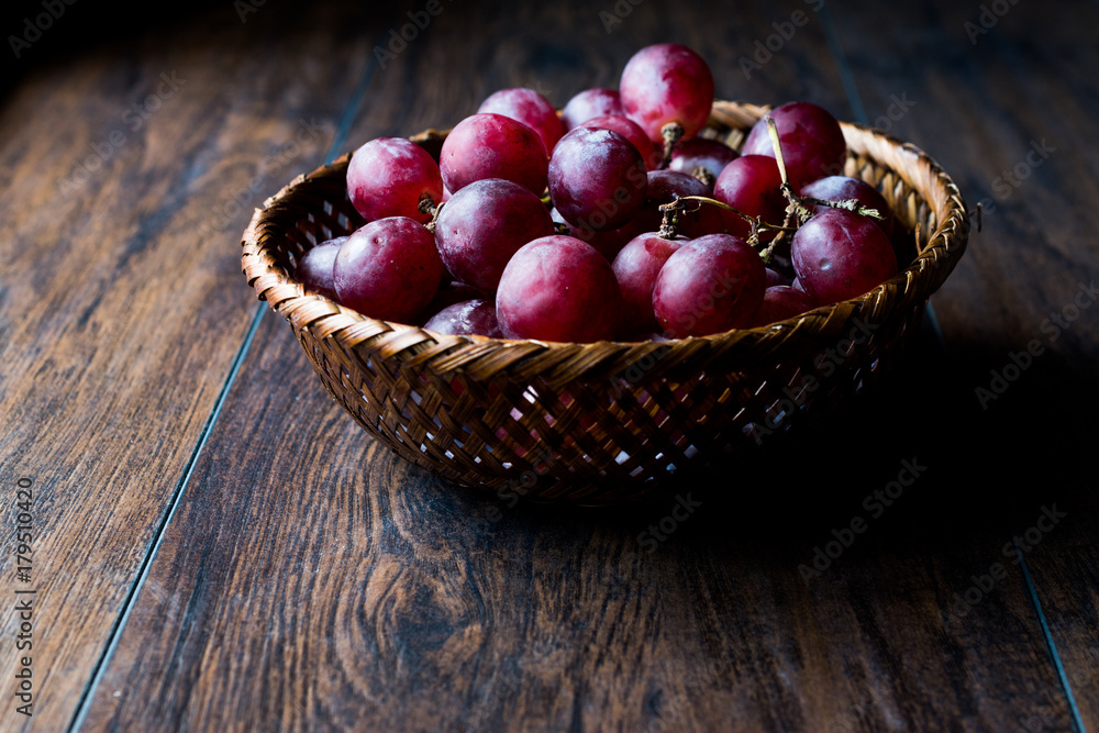 Purple Grapes in wooden basket. Dark Moody Purple Grapes in wooden basket. Dark Moody