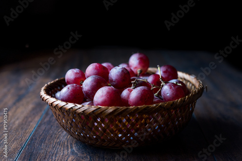 Purple Grapes in wooden basket. Dark Moody
