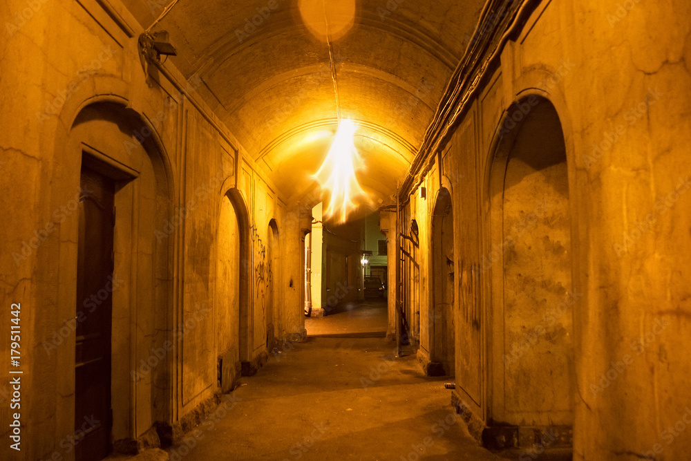 Typical aisle in aged courtyard in the old district of Saint Petersburg (former Leningrad) at night. Russia.
