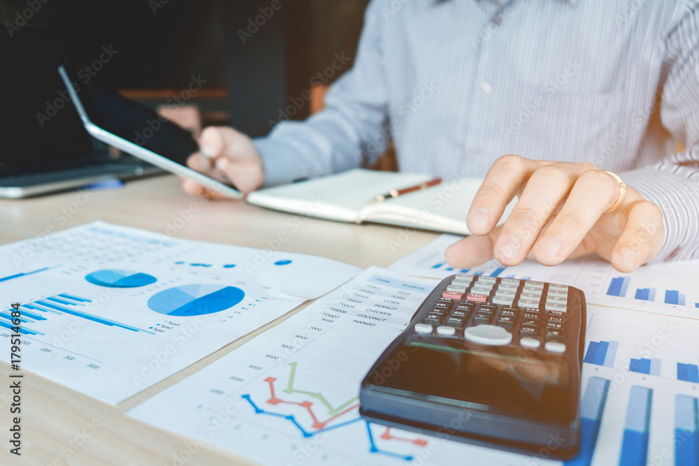 Businessman's hands with calculator at the office and Financial data analyzing counting Businessman's hands with calculator at the office and Financial data analyzing counting