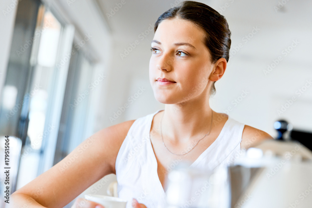 Happy young woman with cup of tea or coffee at home