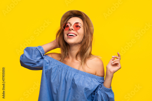 Excited trendy woman laughing on orange