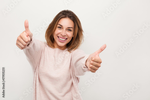Cheerful woman gesturing thumbs up