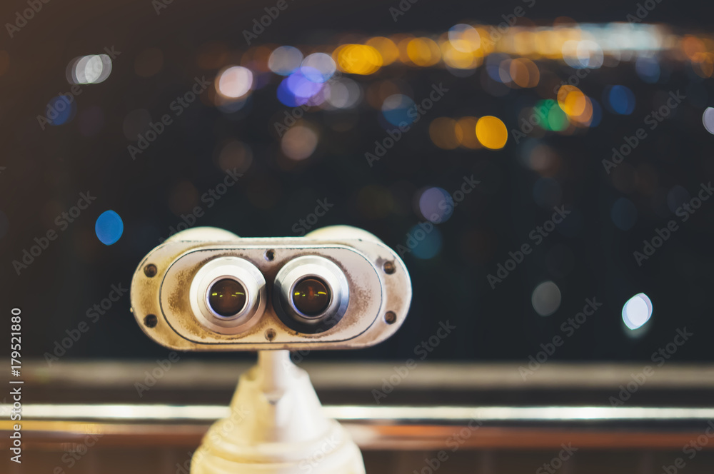 Touristic telescope look at city with view of Barcelona Spain, close up metal binoculars on background viewpoint, hipster coin operated in panorama observation, illumination bokeh light in night blur Touristic telescope look at city with view of Barcelona Spain, close up metal binoculars on background viewpoint, hipster coin operated in panorama observation, illumination bokeh light in night blur