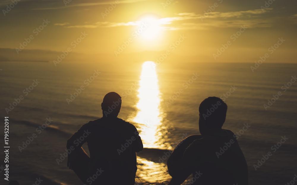 Obraz premium Para facet na tle plaża ocean wschód słońca, sylwetka dwie osoby przytulające się i patrząc widok wieczorny krajobraz morski, romantyczni przyjaciele hipster razem cieszyć się zachodem słońca, podróże wakacje wakacje, koncepcja relaksu
