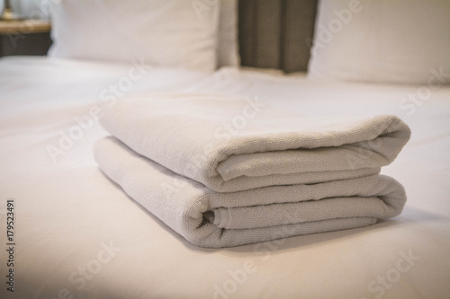 Stack of towels on a bed in a hotel room