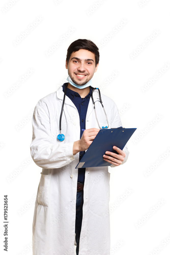 beautiful young doctor in a dressing gown with a stethoscope on a white background in the studio,with the ass, records a medical history beautiful young doctor in a dressing gown with a stethoscope on a white background in the studio,with the ass, records a medical history