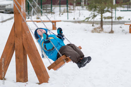 Obraz na płótnie Happy child on swings at a winter park w salonie