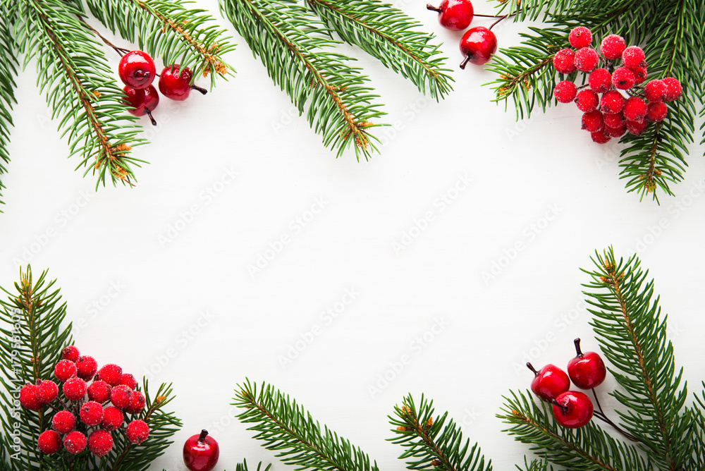 Christmas background with xmas tree and red berries on white wooden background. Merry christmas greeting card, frame, banner. Winter holiday theme. Happy New Year. Flat lay. Stock Photo