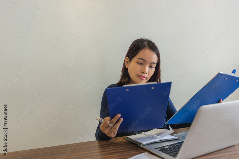 Businesswoman holding folder and reading sales report Businesswoman holding folder and reading sales report