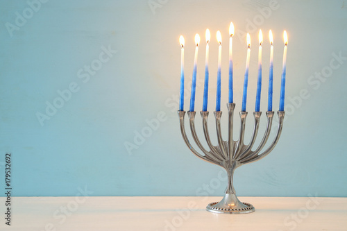 image of jewish holiday Hanukkah background with traditional menorah (traditional candelabra) and burning candles