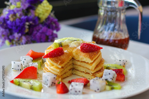 Pancakes for breakfast topped with strawberry and kiwi