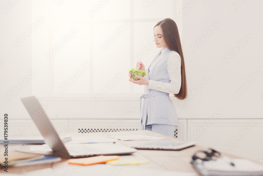 Young business woman eating salad at office Young business woman eating salad at office