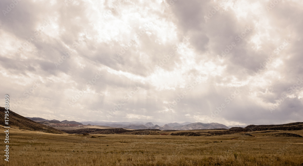 Western Plains Landscape with a Stormy Sky and Rocky Mountains in the Background Western Plains Landscape with a Stormy Sky and Rocky Mountains in the Background