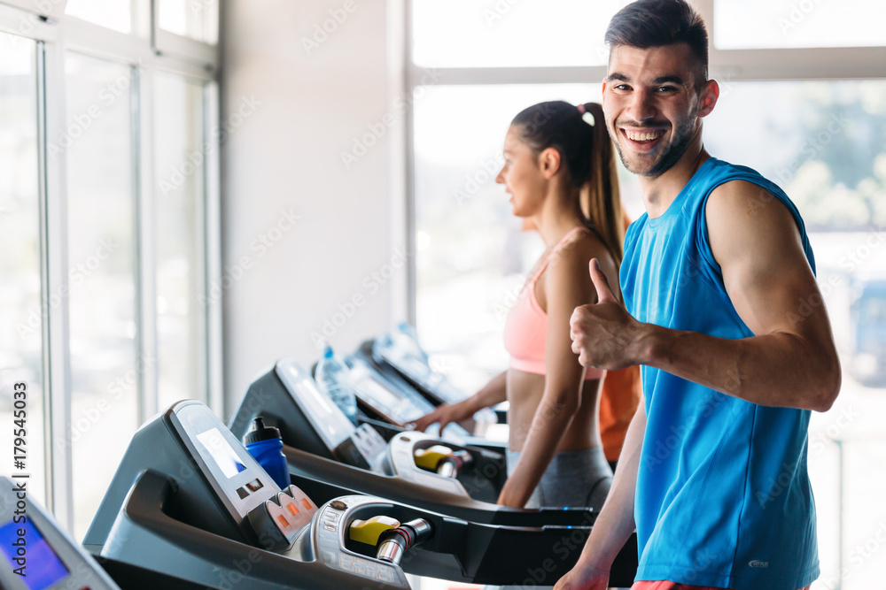 Obraz premium Group of friends exercising on treadmill machine