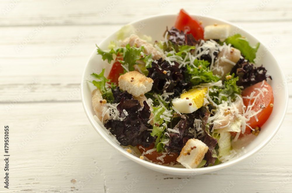 Salad, caesar on white wooden background and copy space Salad, caesar on white wooden background and copy space
