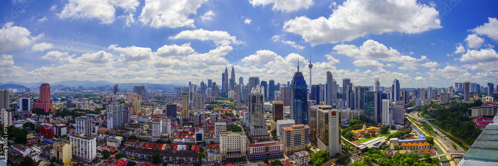 Obraz premium Panoramiczny widok na panoramę miasta Kuala Lumpur z dramatycznym powstawaniem chmur i błękitnego nieba.