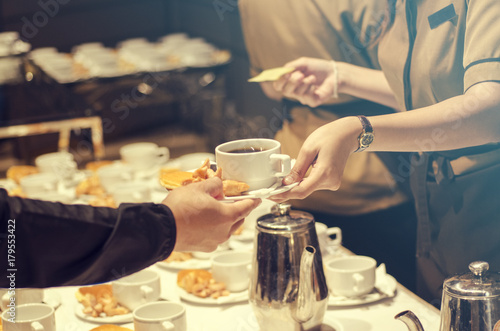 Blurred for Background.The waitress filed a glass of white coffee with the sausage between the brake and the brake food background.