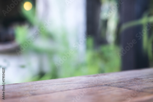 Close up image of a wooden table with blur bokeh of green nature background