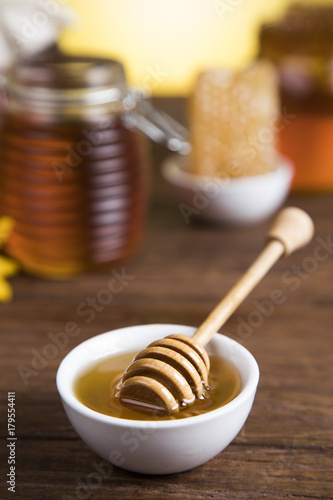 Honey and wooden stick are on a table