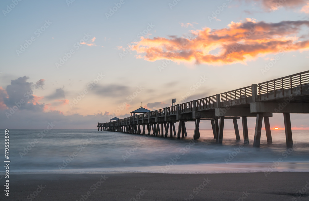 Sunrise over pier with beach